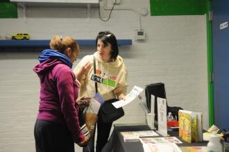 Arjana Topallaj tells a fellow parent about the Literacy in Community program during the resource fair.
