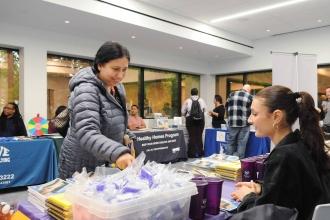 A woman smiles while at an informational table