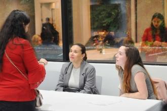 A woman talks to two social workers at a table.