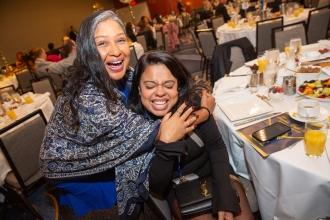 Ely Trachtenberg Award-winner Maria Berrios (seated), who teaches at PS 38 in Brooklyn, gets a congratulatory hug from Judith Newell, a teacher at PS 124 in Brooklyn.