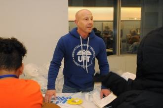 UFT Vice President for Middle Schools Richard Mantell, the architect of the coat drive and luncheon, hands out coats to students.