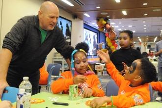 UFT President Michael Mulgrew greets students at a craft table before helping to hand out coats.