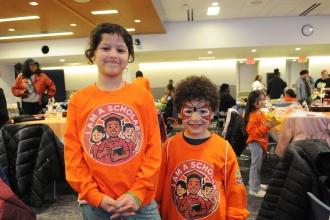 A pair of siblings, ages 8 and 5, show off their face paint and shirts before having lunch.