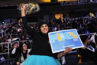A UFT member raises her UFT swag during the March 8 Tier 6 Rally in Albany