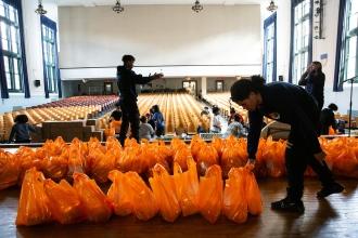 Orange bags filled with food quickly fill the auditorium stage at ISLA before distribution.