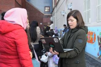 PS 14 teacher Angelica Ortega, who helped launch the pantry during the pandemic, checks in families waiting on line.