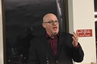 A man speaks at the podium during a legislative reception