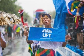 Woman holding UFT banner standing in the rain
