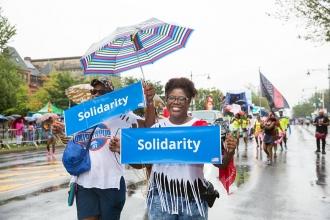 Two people holding signs that say "solidarity"