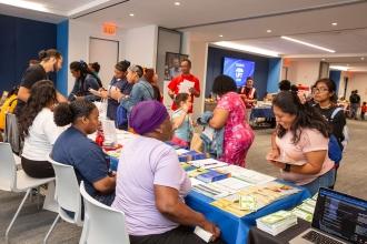 Parents get information at tables during a Bronx family UFT event. 