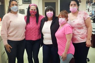 Four staffers pose showing off their pink shirts from PS 146M