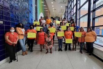 A group of staff members pose together wearing orange