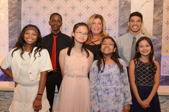 A group of students pose for a group photo with a UFT district representative 