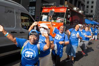 A group of UFT members dance while marching 