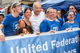 A group of UFT members take a photo with a senator