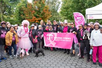 A large group poses for a photo during a breast cancer awareness walk