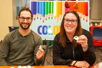 Two adults pose with their custom hacky sacks