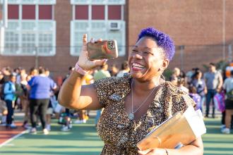 A woman with purple hair takes photos on her phone