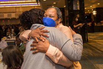 Two women embrace in a big hug
