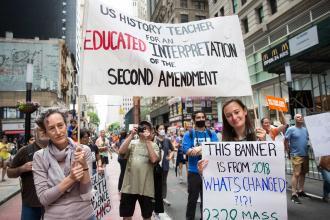 A woman and her daughter hold up signs from a 2018 rally 