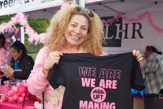 A teacher holds up a breast cancer awareness t-shirt while at a Making Strides Walk in Manhattan