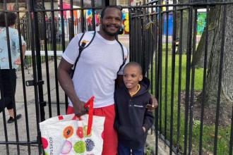 A father and son stand outside a school