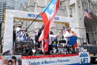 Members celebrate on a float going up Fifth Ave.