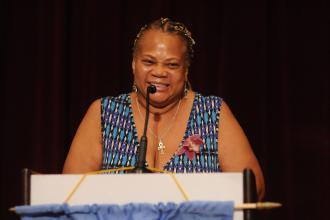 A woman speaks at the podium at the 2024 UFT Retired Teachers Chapter Luncheon