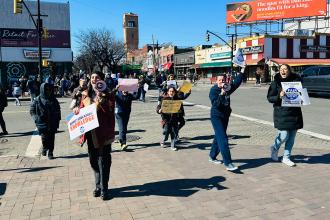 Members march down a street in protest