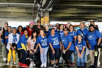 A large group of UFT members take a group photo after getting off the buses