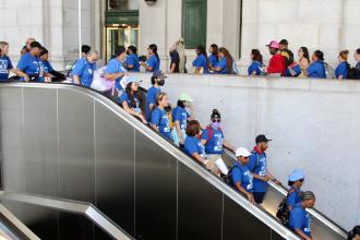 A group of UFT members head down an escalator 