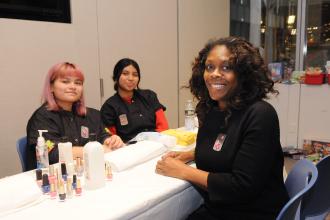 A librarian takes a photo with cosmetology students at the UFT/Coalition for the Homeless holiday toy drive and celebration on Dec. 7, 2024