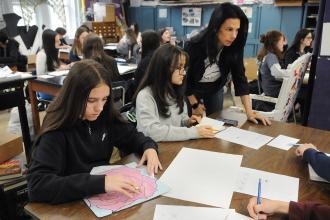 An art teacher works with her students in preparation for an art show at IS 34 on Staten Island.