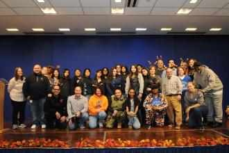 UFT members and staff who volunteered to supervise craft tables and distribute coats — including Vice President for Middle Schools Richard Mantell, kneeling, second from left — get together for a group shot.