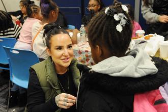 A teacher assists a student at the 2024 UFT Middle School Division’s annual Thanksgiving Luncheon on Nov. 23, 2024 at UFT headquarters. 