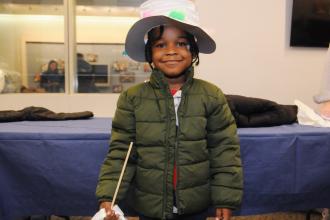 A student models the hat they decorated at a craft station and their brand-new coat at the UFT Middle School Division’s annual Thanksgiving Luncheon on Nov. 23, 2024. 