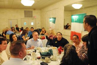 Dinner attendees listen to a waiter giving menu options