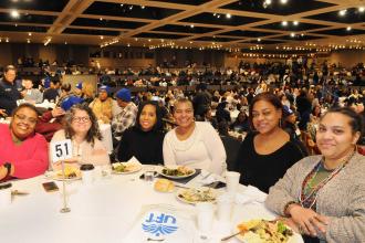 A group of parents in attendance pose for a photo at their table