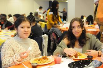 Two students pose for a photo while eating their lunch