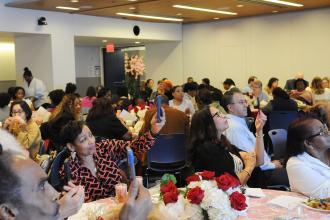 The crowd records an honoree speaking at a nurse celebration