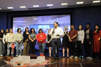Chapter Leader Raul Garcia welcomes members from the stage at Shanker Hall. 