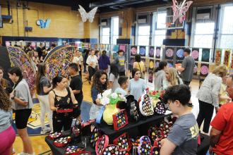 Attendees at the IS 34 art show on Staten Island walk through the gymnasium and look at the artwork made by students.