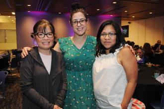 Three women pose for a photo at an awards ceremony