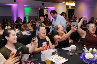 A group of members at a table cheer for an award winner 