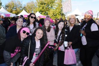 A group of marchers pose for a photo at a breast cancer awareness walk. 