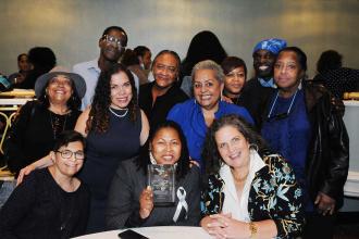 A group of members pose for a photo at a table. 
