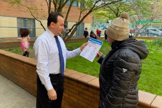 A teacher hands a flier to a parent
