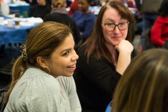 Social workers chat with colleagues at their table.