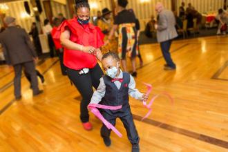 A woman dances with her son.