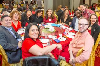 Chapter Leader Sandy Wong (standing, right) of PS 30 in the Bronx stops by to visit with UFT members from Queens, including Borough Representative Tabio DeCruz (far left).